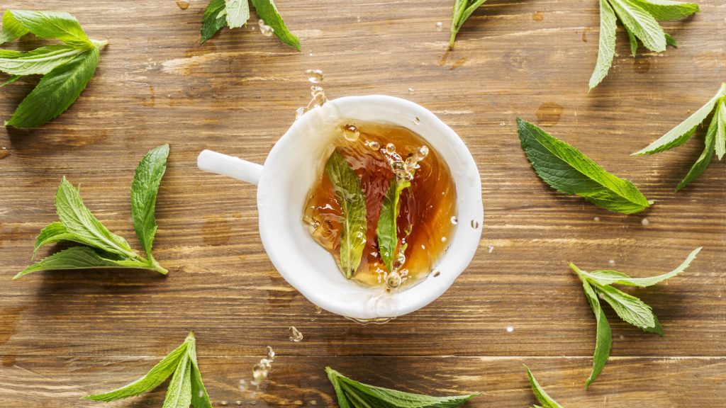 Tasse de thé entourée de feuille de verveine